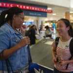 Crystal Toombs, associate provost of adult & graduate studies, speaks with Crystal Wang near baggage claim of Hartsfield-Jackson International Airport.