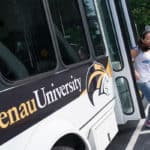 Cathy Wu jumps off the bus while stopping for breakfast.