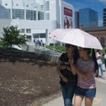 From center left, Daisy Qiu and Crystal Wang walk on a sidewalk near the High Museum of Art in Atlanta.