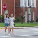 Rachel Pei and Lily Li wave while walking across campus.